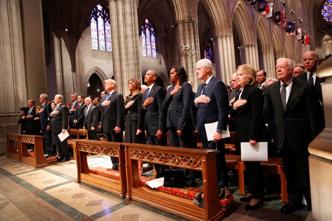 President Trump and four former presidents — George W. Bush, Barack Obama, Bill Clinton and Jimmy Carter and their wives hold their hands to their hearts at George H.W. Bush's memorial service in Washington.