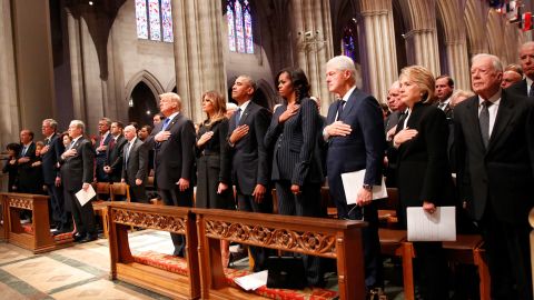 President Trump and four former presidents — George W. Bush, Barack Obama, Bill Clinton and Jimmy Carter and their wives hold their hands to their hearts at George H.W. Bush's memorial service in Washington.