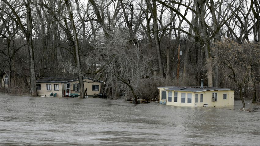 The rising waters of the Elkhorn River south of Arlington, Neb., Thursday, March 14, 2019, floods cabins. Evacuations forced by flooding have occurred in several eastern Nebraska communities. (AP Photo/Nati Harnik)