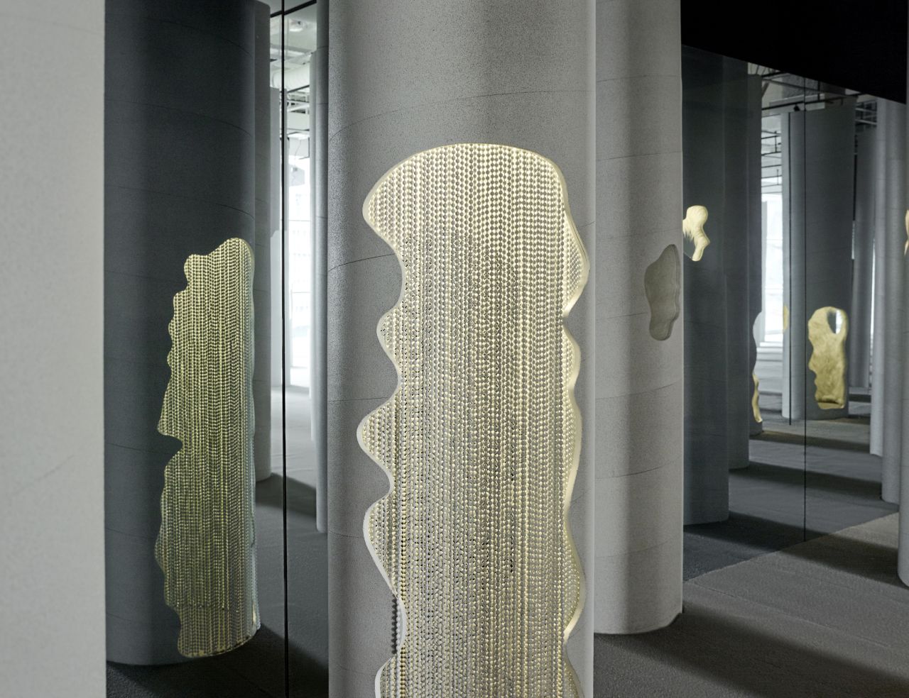 The "Lost and Found" exhibition features a grid-like forest of white columns that emerge from the ground at varying levels like stalagmites.