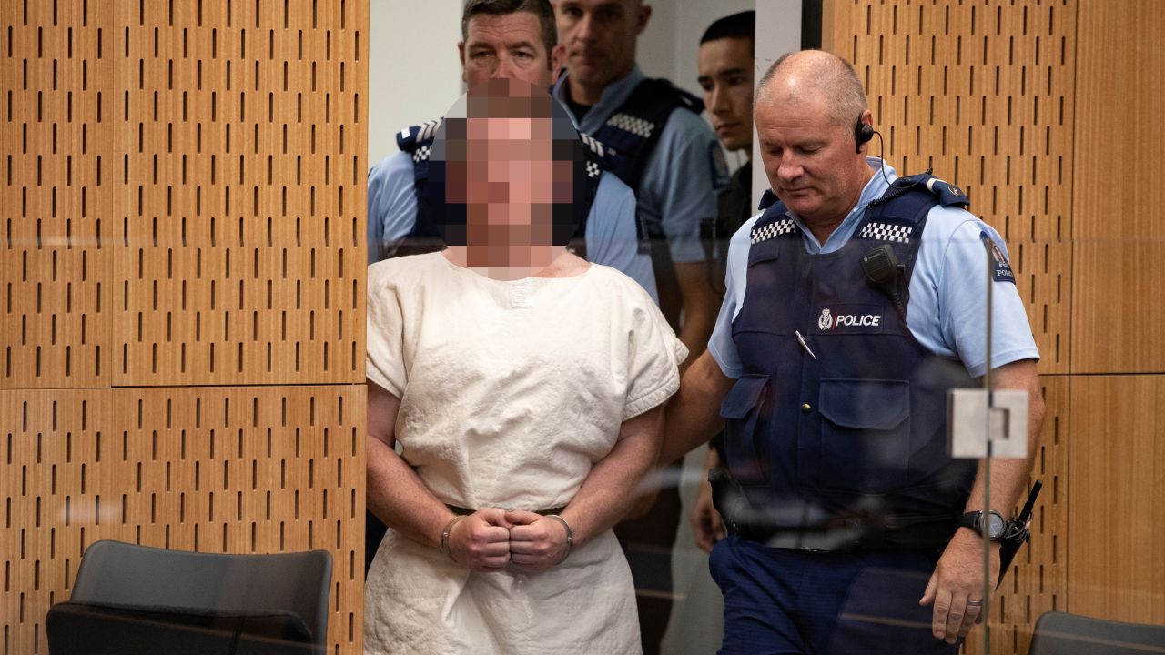 Tarrant is escorted into Christchurch District Court on Saturday. The judge ruled pictures of the suspect in court must have his face blurred.