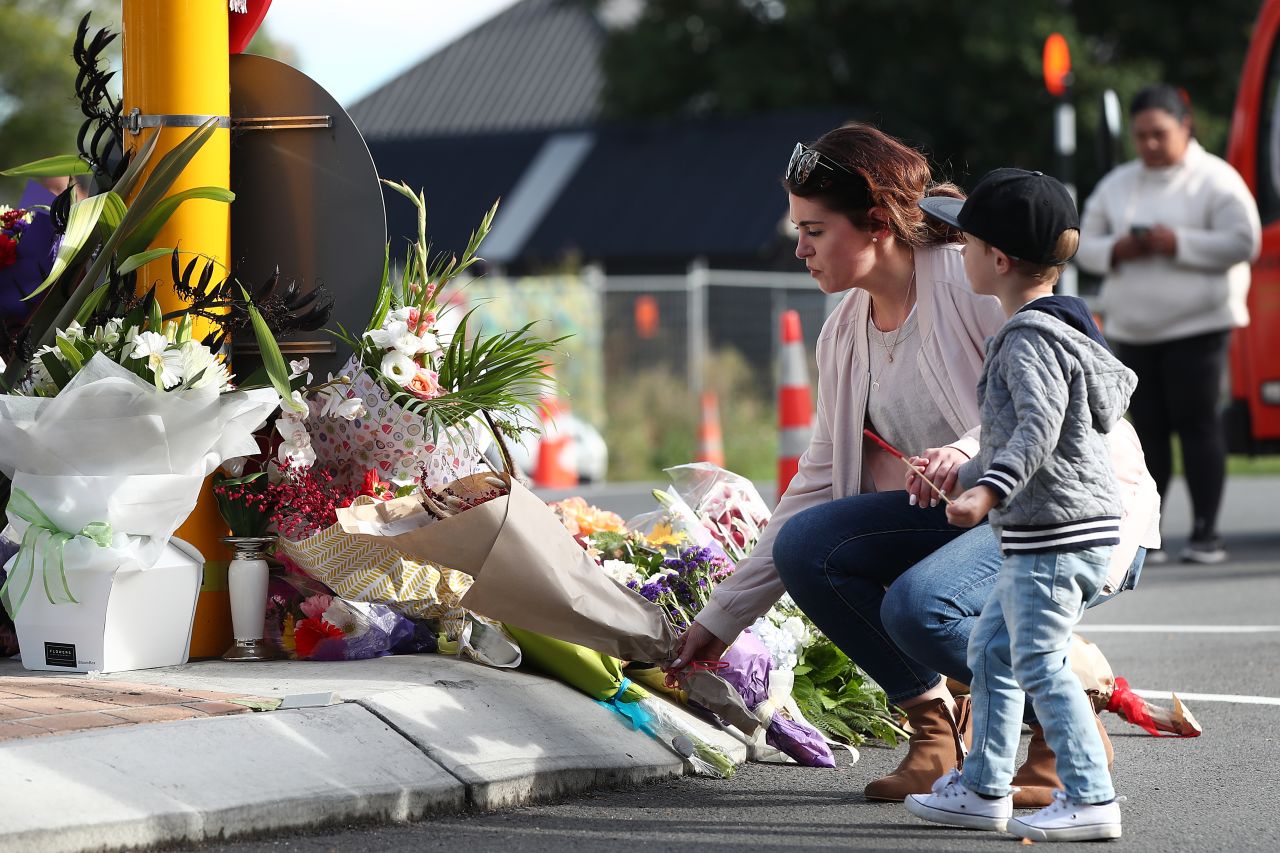 A woman lays flowers at Deans Avenue near Al Noor Mosque in Christchurch on March 16. More than 40 people were killed at that mosque, according to authorities