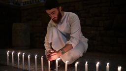 A well-wisher helps to light 49 candles as he pays respects to victims outside the hospital in Christchurch on March 16, 2019, after a shooting incident at two mosques in the city the previous day.