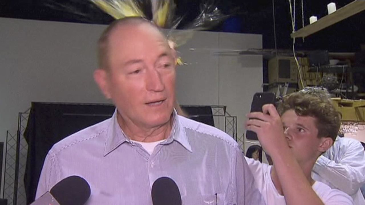 A teenager cracks an egg on the head of Australian Sen. Fraser Anning on Saturday in Melbourne.   