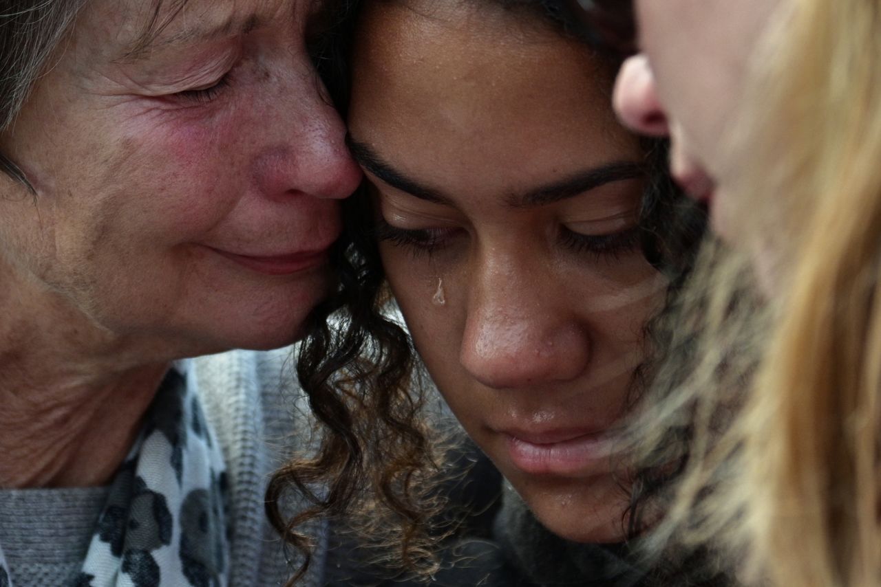 Residents cry after leaving flowers in tribute to victims in Christchurch on March 17.