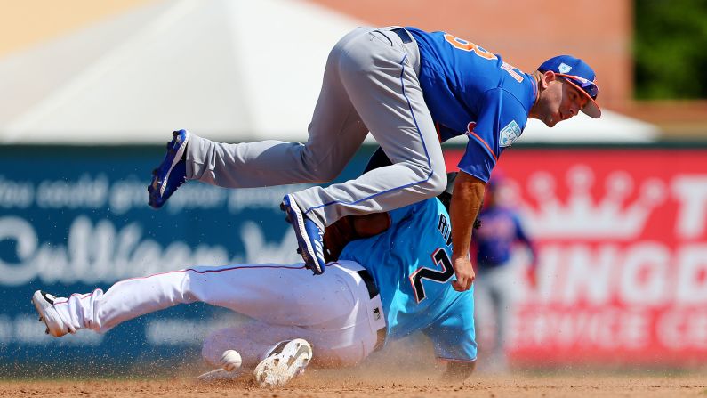 Yadiel Rivera, bottom, of the Miami Marlins steals second base as he upends second baseman Danny Espinosa of the New York Mets during the seventh inning of a spring training baseball game at Roger Dean Stadium in Jupiter, Florida, on Tuesday, March 12.