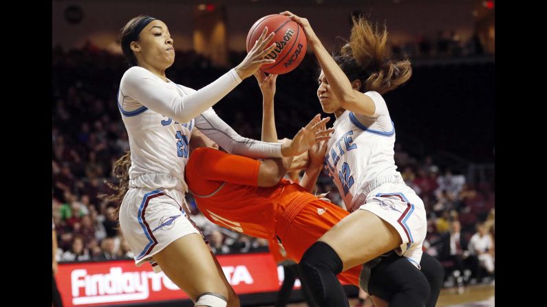 New Mexico State guard Dominique Mills, left, and teammate Kalei Atkinson, right, go after a loose ball over Texas-Rio Grande Valley guard Quynne Huggins during an NCAA college basketball game in the championship of the Western Athletic Conference women's tournament in Las Vegas on Saturday, March 16.