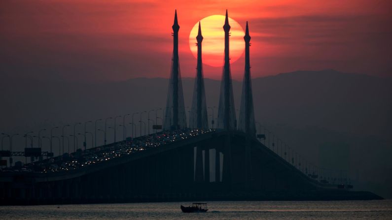 <strong>15. Penang, Malaysia. </strong>The sun rises over the Penang bridge in Penang island, where visitors can explore the Malaysian rainforest, which is home 20% of the world's animal species and uncountable plant species.