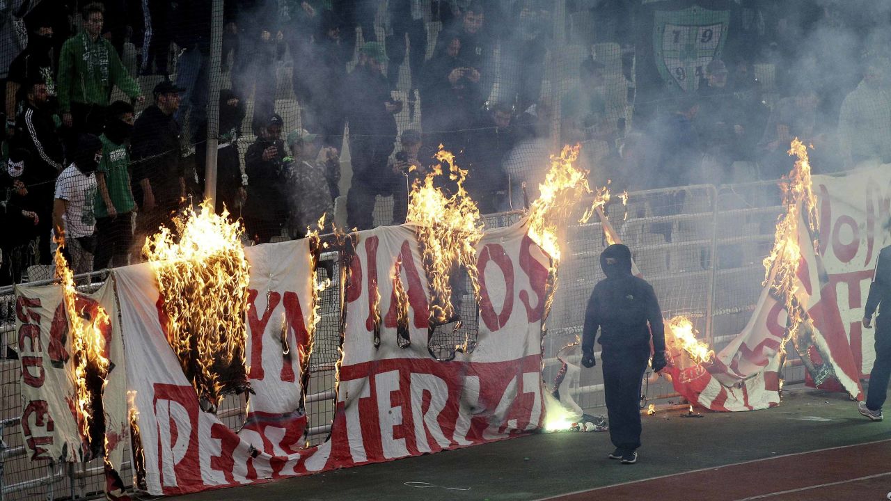 Fans burn a banner in front of the stands during the game, which was ultimately abandoned after 70 minutes due to persistent crowd trouble.