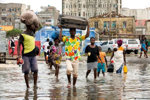 People carry their personal effects in the aftermath of Cyclone Idai in Beira on Friday, March 15.
