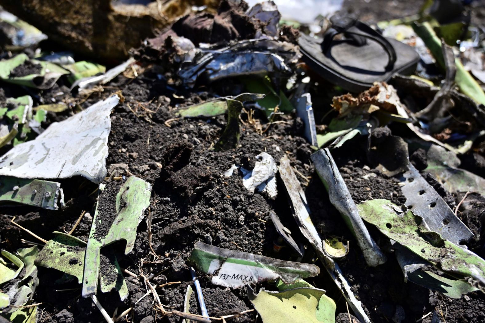 Debris including a charred part of an onboard safety instruction card is seen at the crash site of an Ethiopian Airlines flight on March 16, at Hama Quntushele village near Bishoftu in the Oromia region.