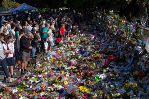 Floral tributes to those who were gunned down at the two mosques are seen against a wall bordering the Botanical Garden in Christchurch on March 19, 2019. New Zealand Prime Minister Jacinda Ardern vowed never to utter the name of the gunman as she opened a sombre session of parliament with an evocative "as-salaam alaikum" message of peace to Muslims.