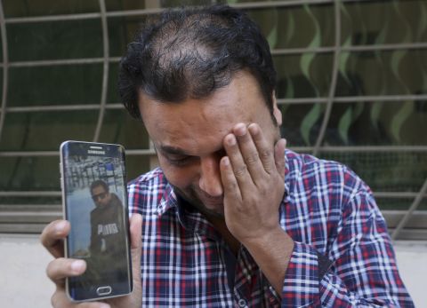 A relative weeps while showing the picture of Sohail Shahid, a Pakistani citizen who was killed in the Christchurch mosque shootings, on his cell phone outside his home in Lahore, Pakistan, Sunday, March 17. Pakistan's foreign ministry spokesman says three more Pakistanis have been identified among the dead, increasing the number of Pakistanis to nine killed in the mass shootings at two mosques in the New Zealand city of Christchurch.