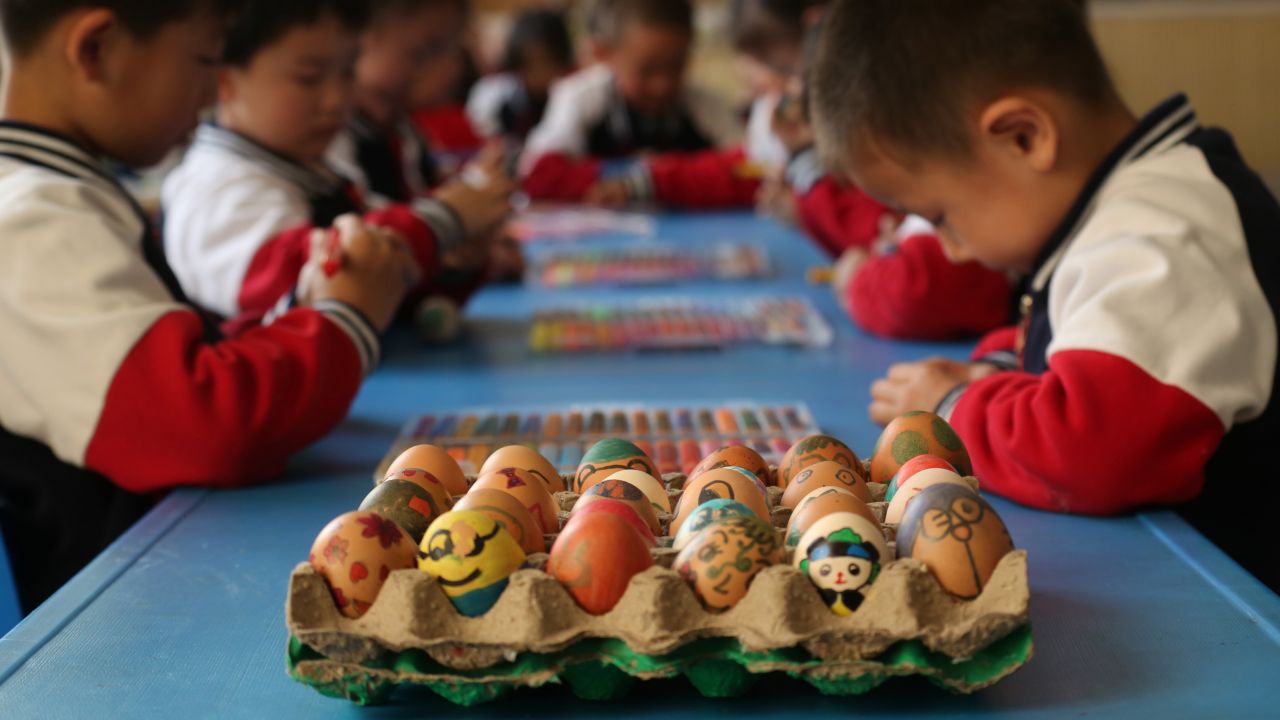 <strong>Chunfen.</strong> Children handle eggs painted with Chinese characters and colors to mark Chunfen (vernal equinox) at a kindergarten in Binzhou in China's Shandong province on March 21, 2018.