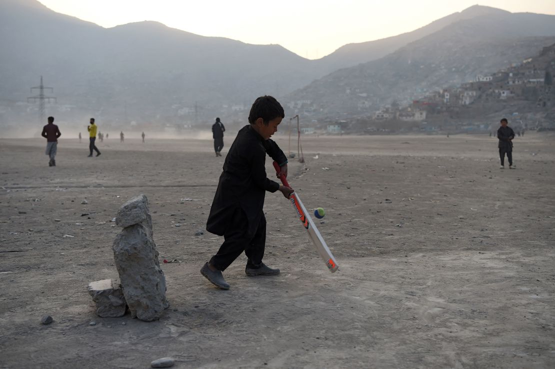 An Afghan boy bats in front of a makeshift set of stumps at an esplanade at Shuhada Lake in Kabul -- a city now obsessed by the sport.