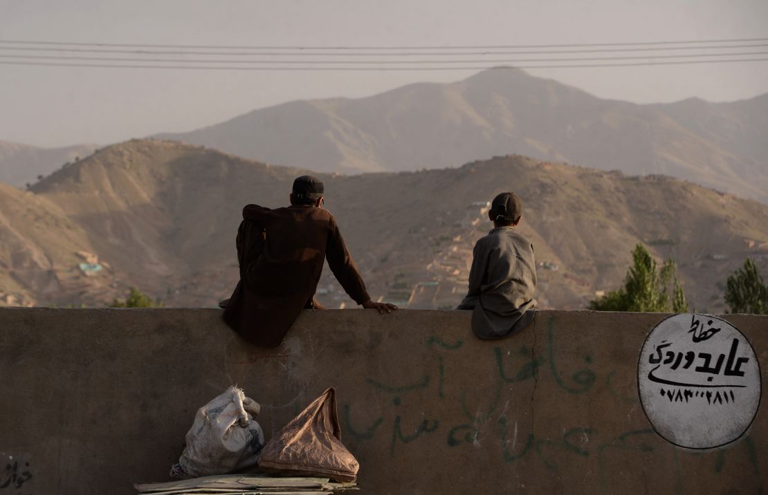 A pair of young Afghans sit on a wall as they watch a game on the outskirts of Kabul. "When I started filming them, they didn't have a grass pitch in the whole country. A lot of the guys had never played with a leather ball," Albone reflects.