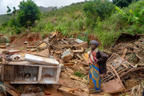 An elderly woman stands amid her destroyed belongings on March 19 in Chimanimani, an area on the border of Mozambique and Zimbabwe. 