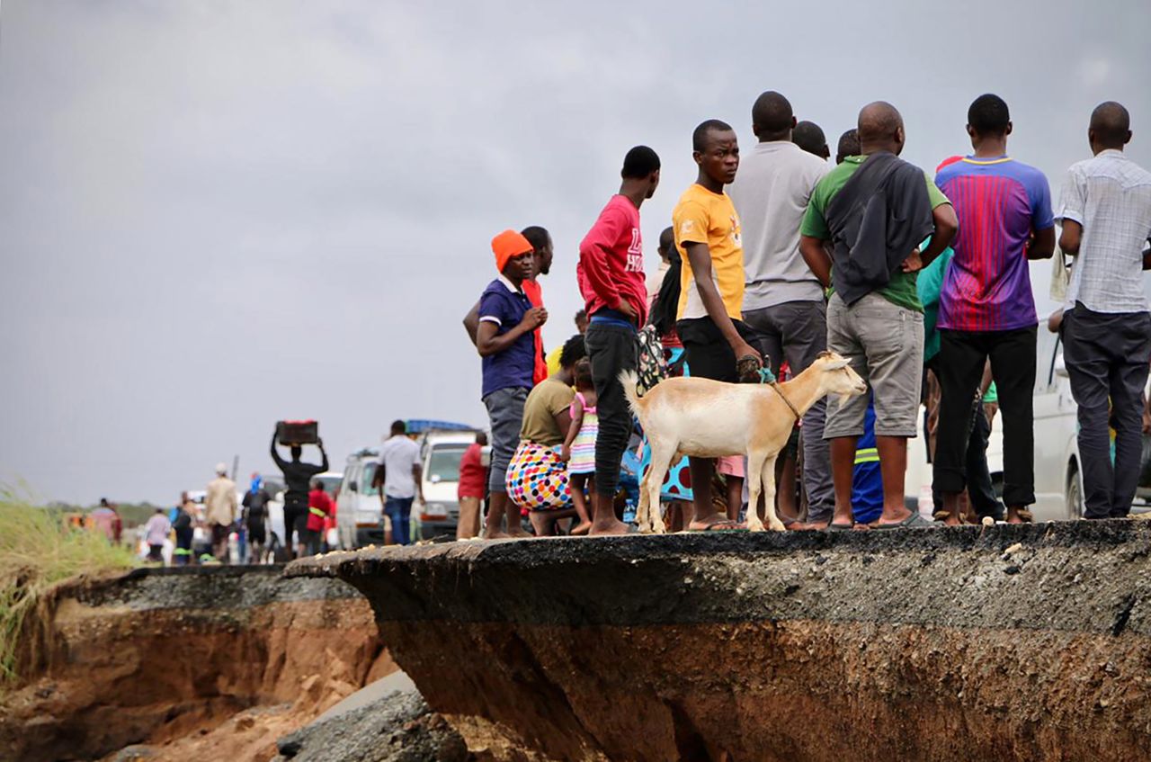 Locals stand at the edge of a damaged section of road between Beira and Chimoio, Mozambique, on March 19.