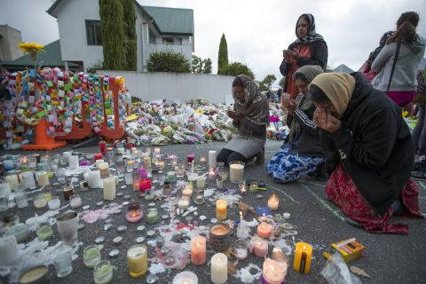 People mourn at a makeshift memorial site near the Al Noor mosque in Christchurch, New Zealand, on Tuesday, March 19. Streets near the hospital that had been closed for four days reopened to traffic as relatives and friends of the victims of last week's mass shootings continued to stream in from around the world.