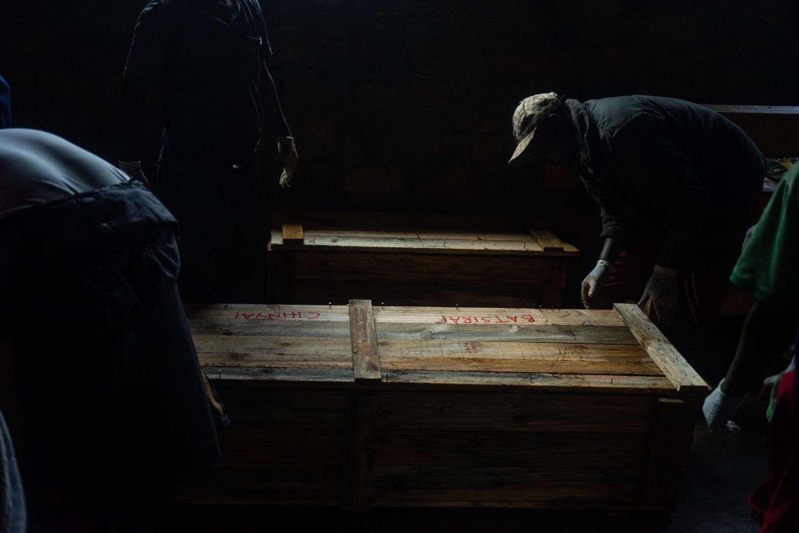 A man closes improvised caskets at the morgue in Chimanimani on Monday, March 18.