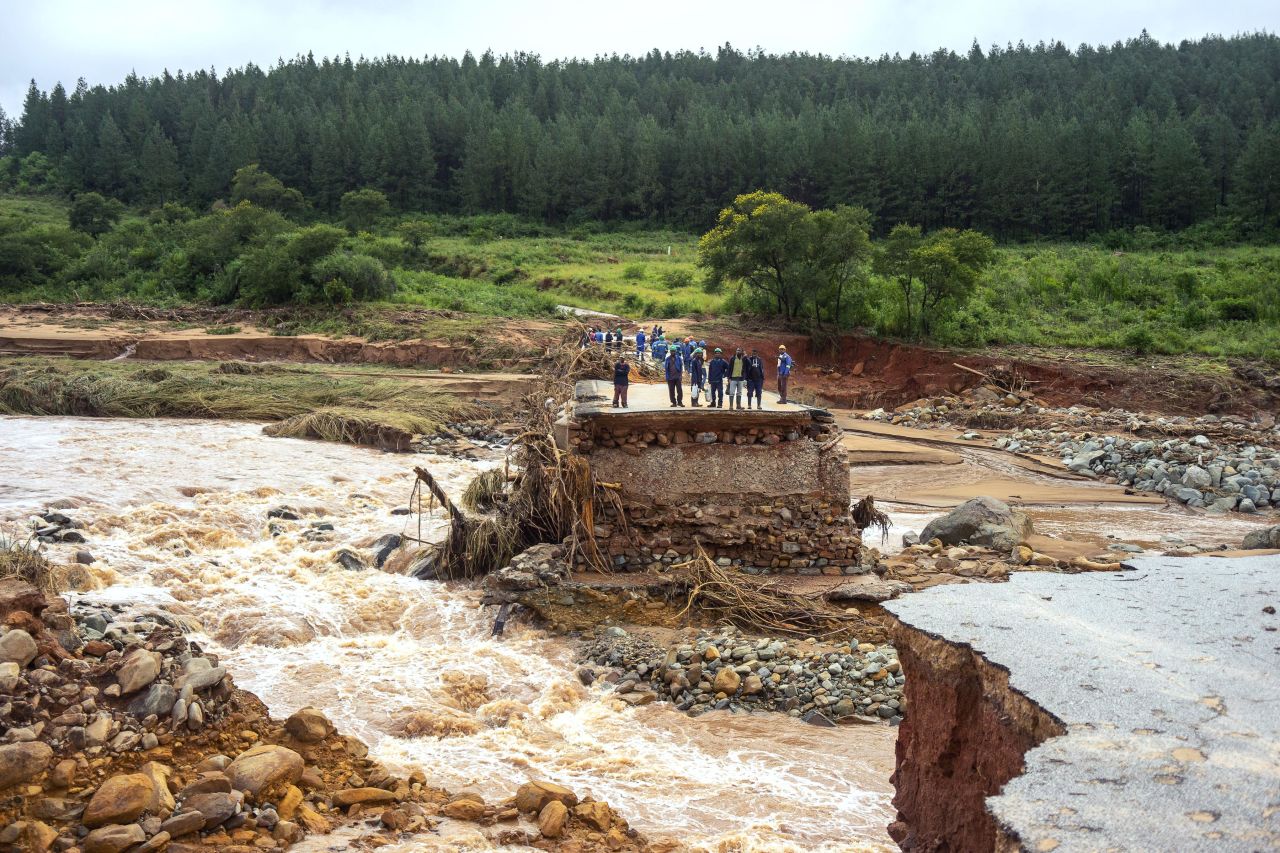 Timber company workers stand on a damaged road on March 18 in Chimanimani.
