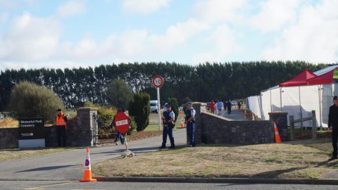 New Zealand police guard the entrance to Memorial Park Cemetery, where the first of 50 people killed in Friday's shooting will be buried.