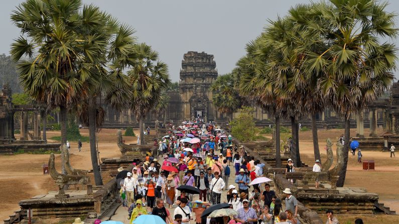 <strong>Siem Reap, Cambodia:</strong> Crowds of tourists shield themselves from the sun on a warm day at the sprawling Angkor Wat temple, believed to be the largest religious monument in the world.