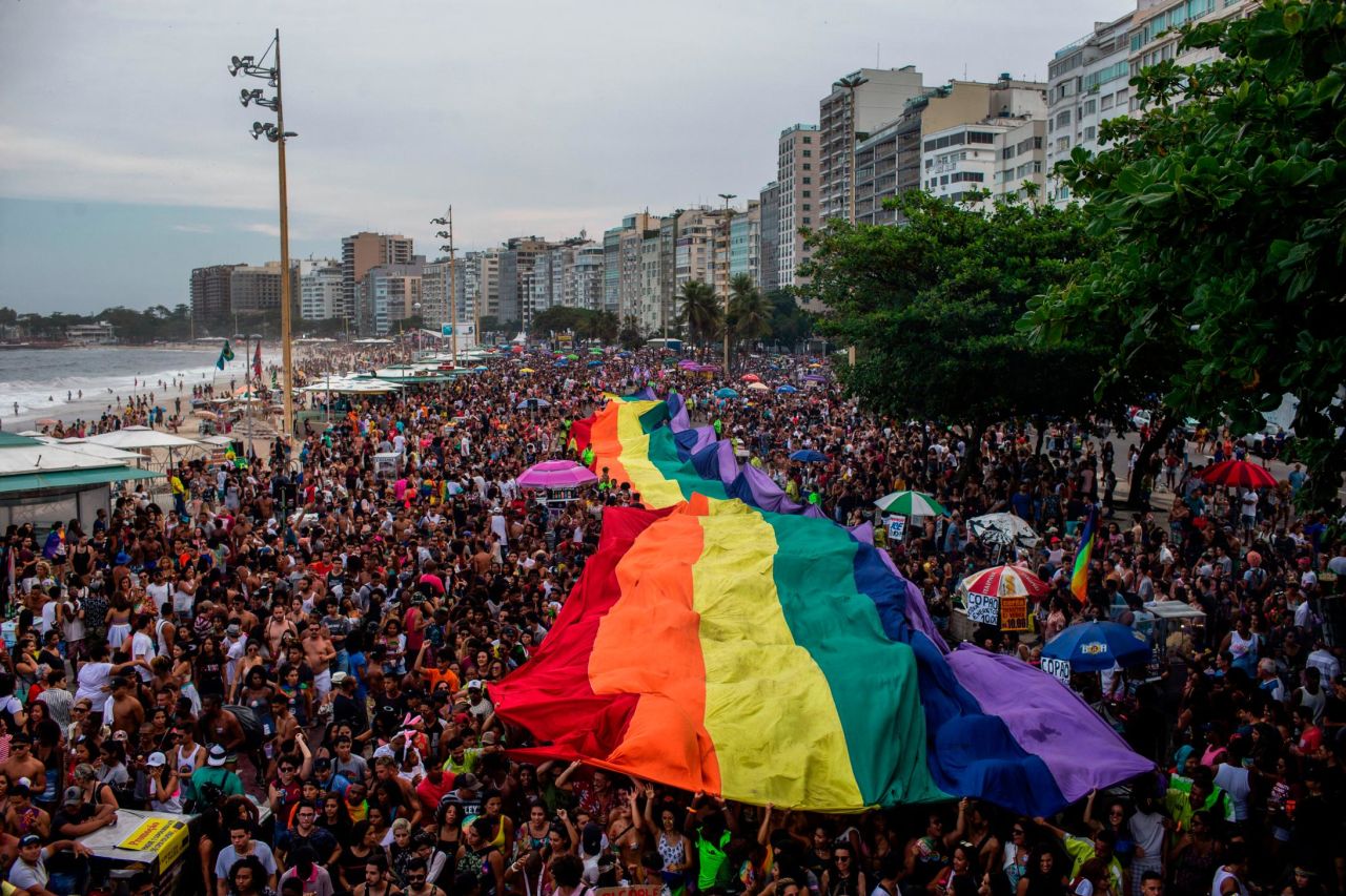 <strong>Rio de Janeiro, Brazil</strong>. Crowds hold up a giant rainbow flag during the 2018 Pride parade at Copacabana Beach.