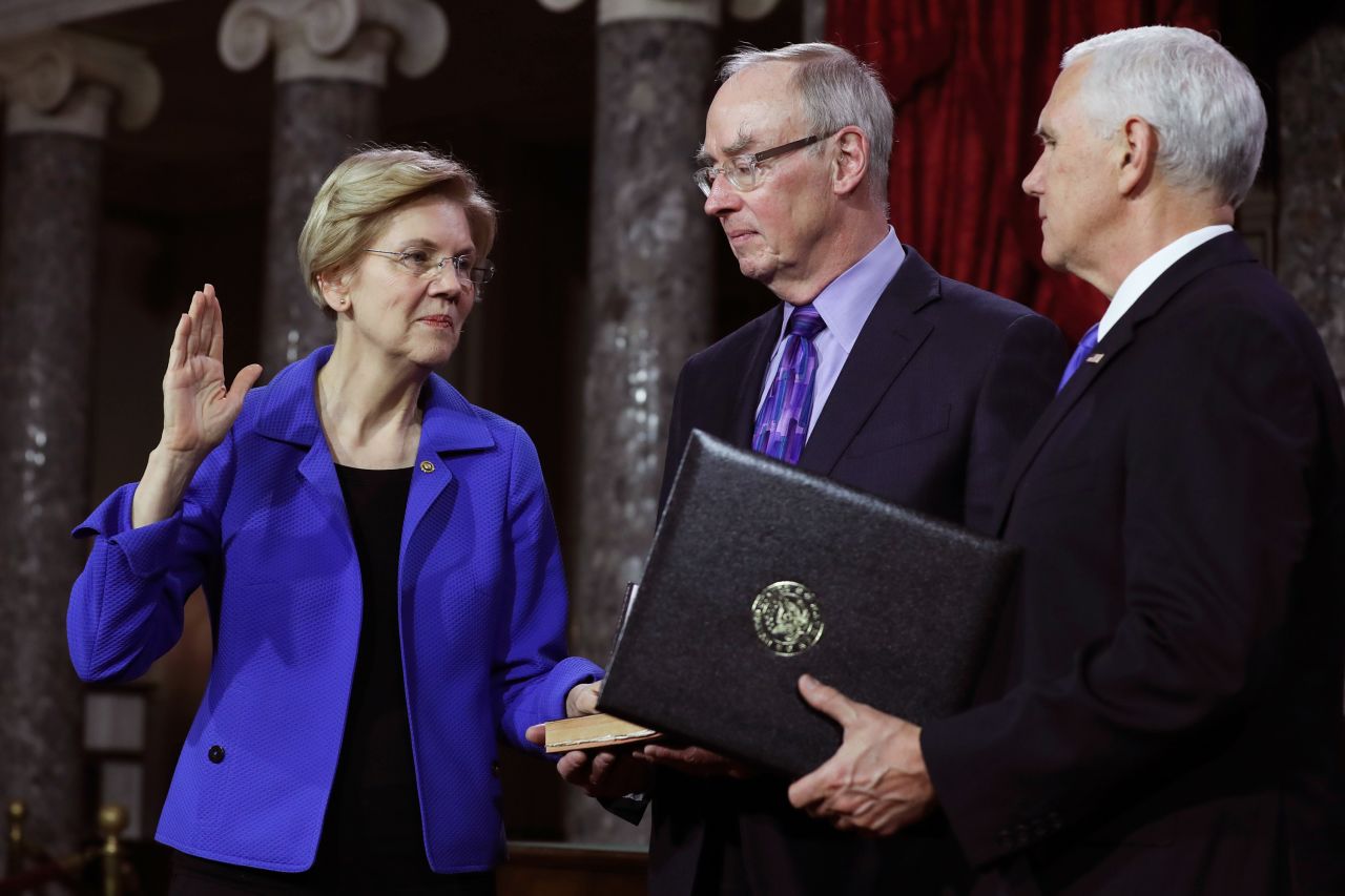 Warren was re-elected in 2018. Here, she is joined by her husband, Bruce Mann, as Vice President Mike Pence re-enacts her swearing-in.