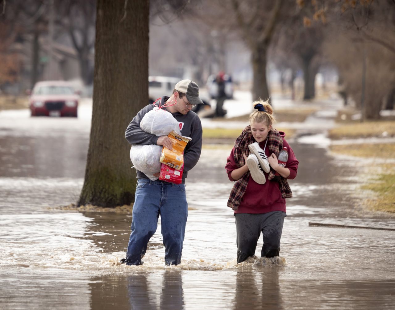 Anthony Thomson, left, and Melody Walton make their way out of a flooded neighborhood in Fremont on March 17.