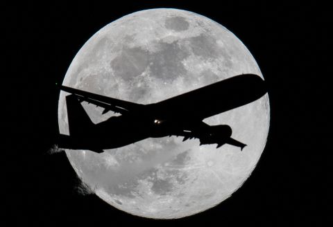  An aircraft crosses the March supermoon as it prepares to land at Frankfurt Airport.