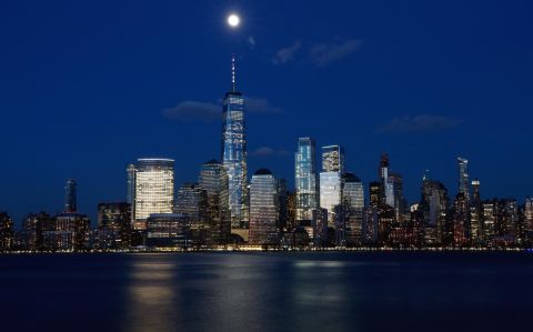 The moon rises above One World Trade Center at sunset in New York City on March 19, as seen from Jersey City, New Jersey.