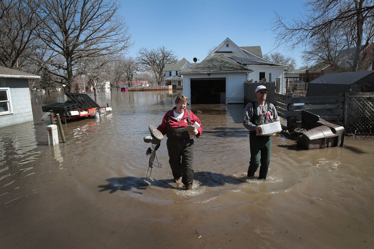 Bill Peeler, right, helps his friend Kathy Drummond remove items from her flooded home in Hamburg on March 20.