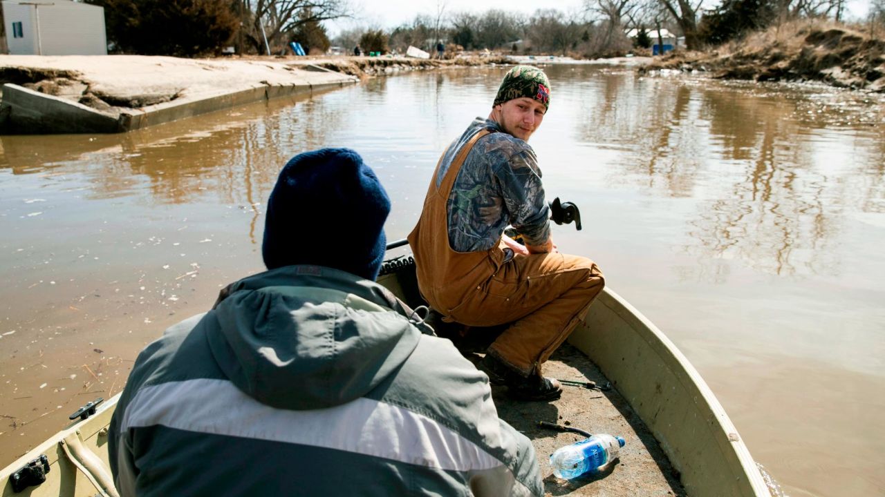 Helmut Shea Kaukver III and Tim Rockford return to their neighborhood in Bellwood, Neb., which was only accessible by boat because of floodwaters.