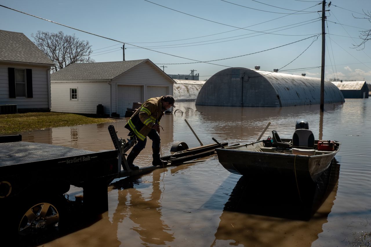 Bryce Moran loads a boat back onto a truck after going to look at his office and seeing that it was completely flooded in Hamburg on March 20.