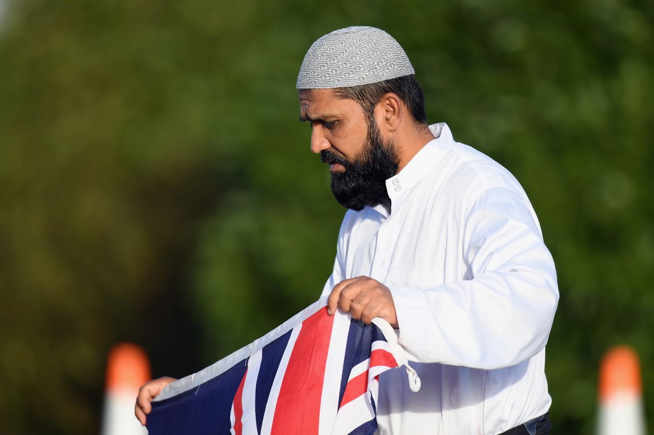 A mourner holds a New Zealand flag during a mass burial at Memorial Park Cemetery in Christchurch on March 22.