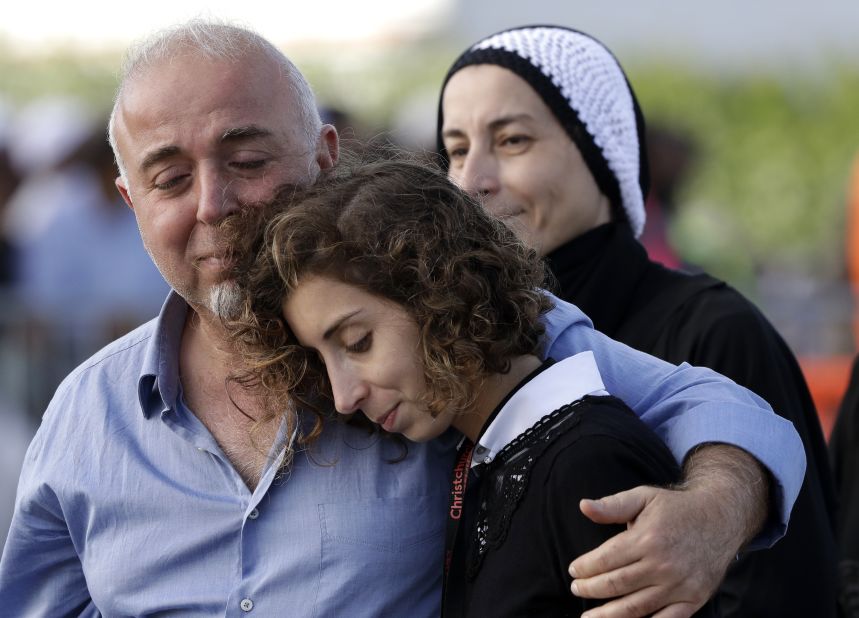 Mourners embrace following a burial ceremony at Memorial Park Cemetery in Christchurch on March 22.