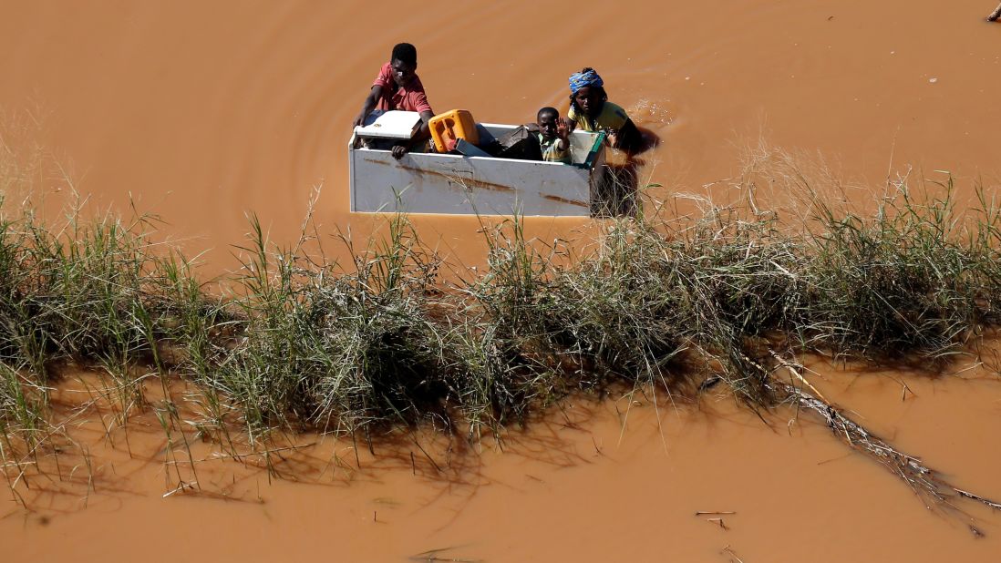 A child is transported via a refrigerator in flooding caused by Cyclone Idai in Buzi, Mozambique, on Thursday, March 21.