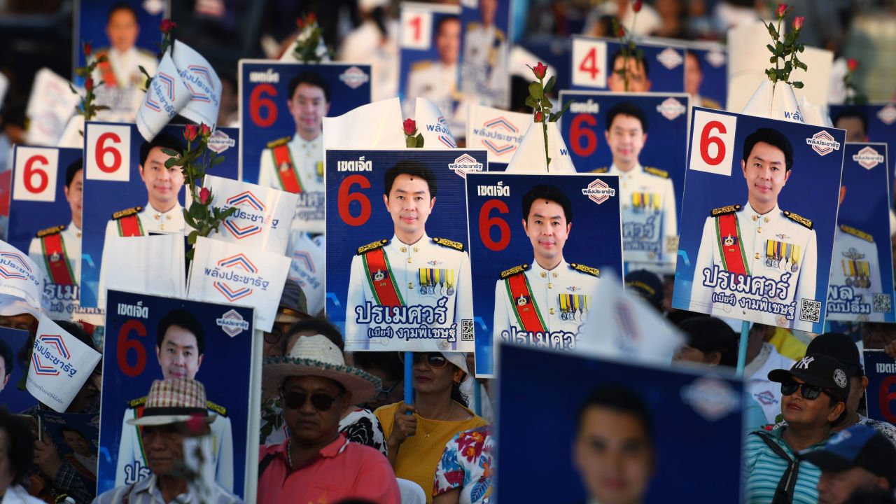 Supporters of the Phalang Pracharat party hold placards in support of their candidates during a campaign rally in Chonburi province on March 21, 2019.