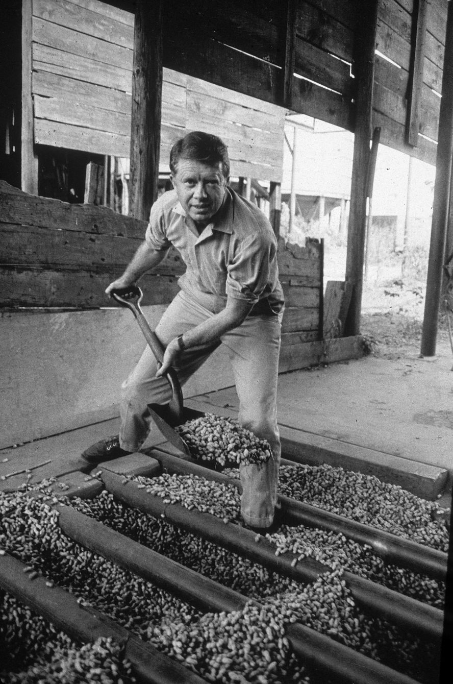 Carter shovels peanuts in the '70s. Carter was the son of a peanut farmer, and he took over the family business in 1953 before his political career took off.