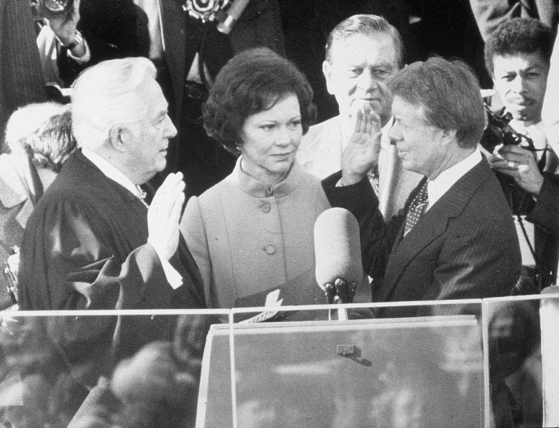 Chief Justice Warren Burger swears Carter into office on January 20, 1977, while Rosalynn Carter looks on.