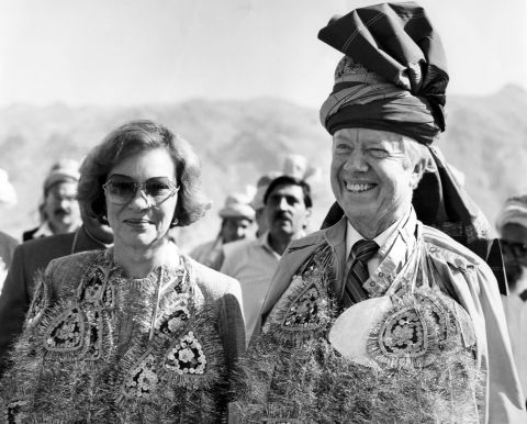 The Carters wear glittering garlands and a turban given to them by Pakistani tribesmen at the Pakistan-Afghanistan border in November 1986. They also received a pair of rams.