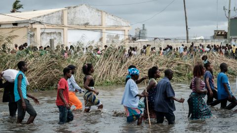 People carry Chinese rice from a warehouse surrounded by water after Cyclone Idai hit the area, in Beira, Mozambique.
