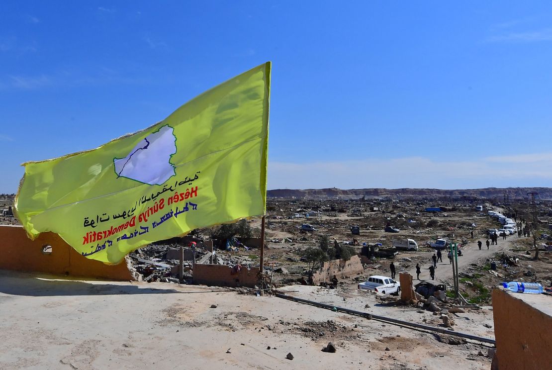 The SDF flag flutters atop a building in Baghouz.