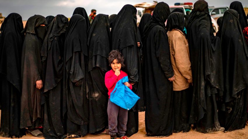 TOPSHOT - Fully-veiled women and children queue at a screening point as hundreds of civilians, who streamed out of the Islamic State group's last Syrian stronghold, arrive in an area run by US-backed Syrian Democratic Forces outside Baghouz in the eastern Syrian Deir Ezzor province on March 5, 2019. - Shell-shocked and dishevelled, hundreds of women and children stumbled through eastern Syria's windswept desert carrying what little they could after fleeing the IS group's final speck of territory. (Photo by Delil SOULEIMAN / AFP)        (Photo credit should read DELIL SOULEIMAN/AFP/Getty Images)