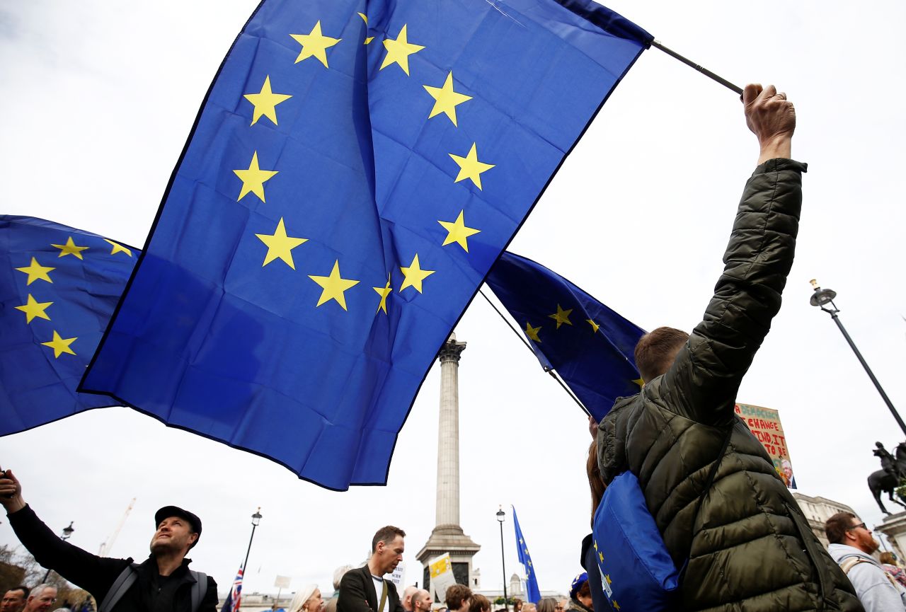 European Union supporters, calling on the government to give Britons a vote on the final Brexit deal, wave EU flags as they participate in the march in central London.