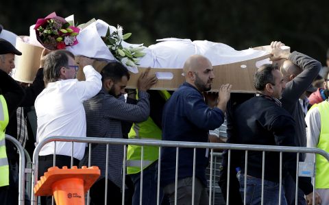 Mourners carry a body at Memorial Park Cemetery in Christchurch on March 22 as funerals continued a week after the deadly attacks.