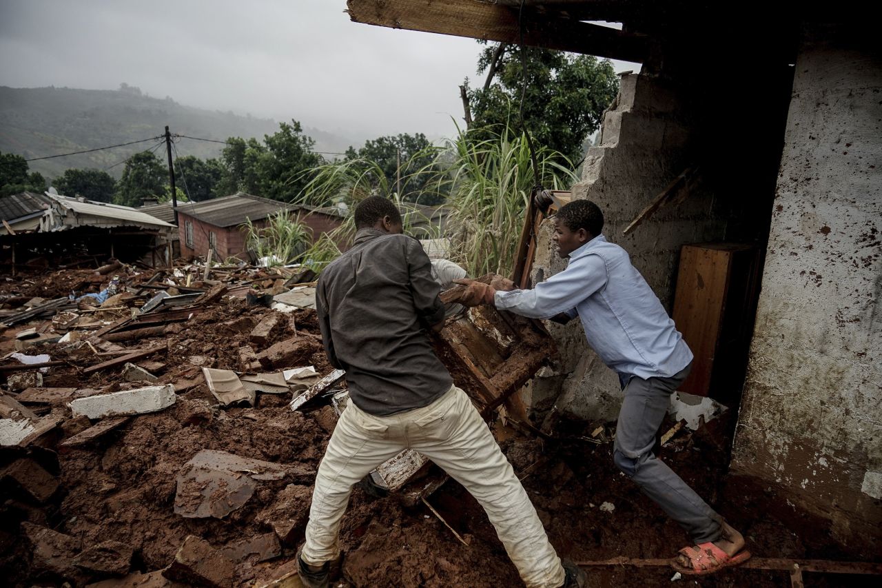 Men try to salvage appliances from a house damaged by the cyclone in Chimanimani, Zimbabwe, on March 23.