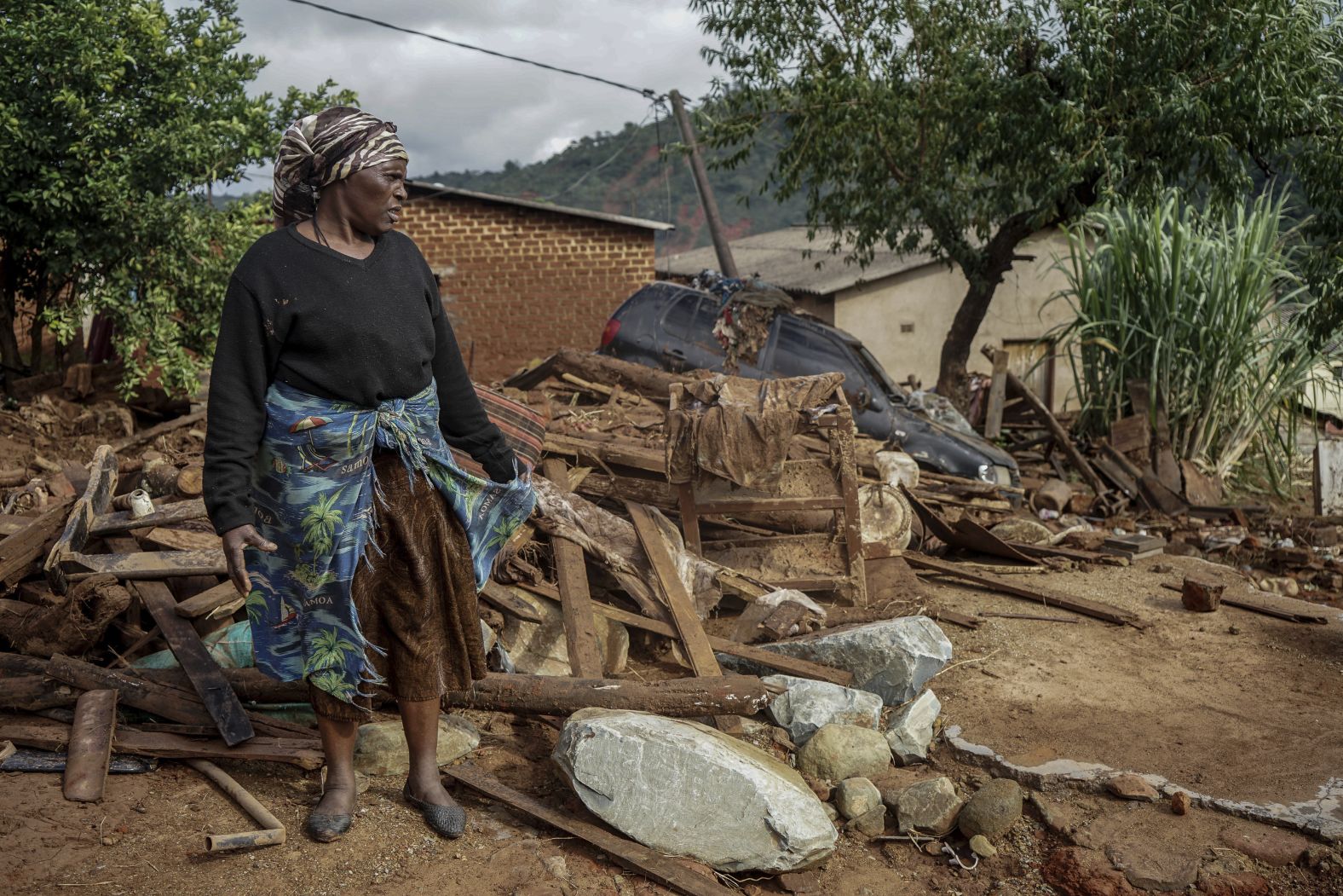 Jessica Mhonderi stands in front of what used to be her son's home in Chimanimani, Zimbabwe, on March 23.