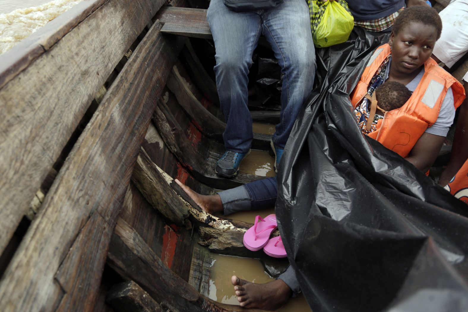 Veronica Fatia carries her 2-year-old daughter as they travel in a boat to Buzi district outside Beira, Mozambique, on Saturday, March 23.